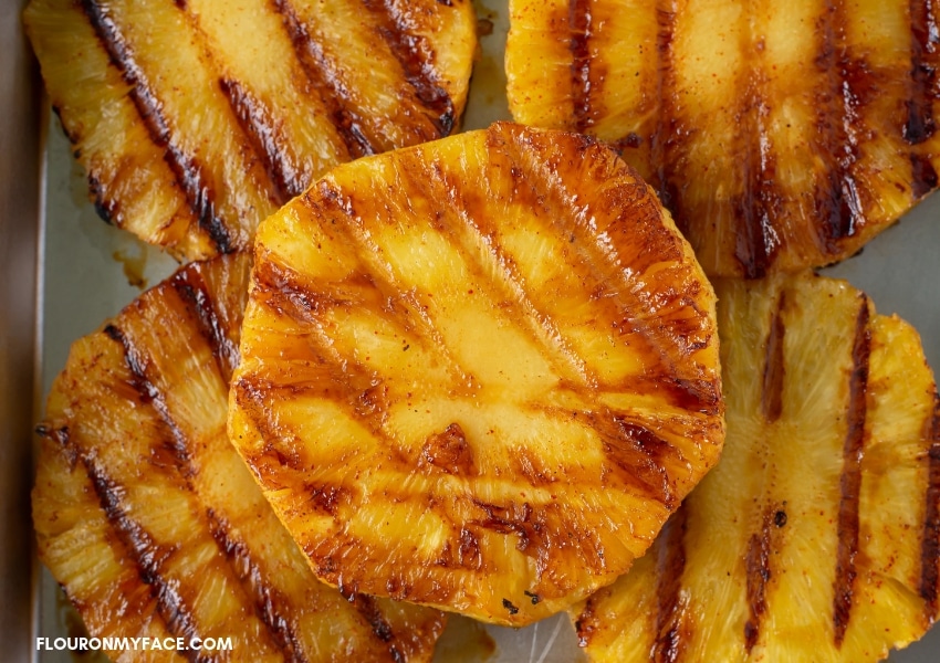 a close up photo of Chili Lime Grilled Pineapple slices on a baking tray