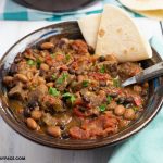a brown bowl filled with a serving of Crock Pot Salsa Verde Beef Stew
