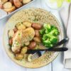 A dinner plate with a serving of crock pot chicken and potatoes with a side of steamed broccoli.