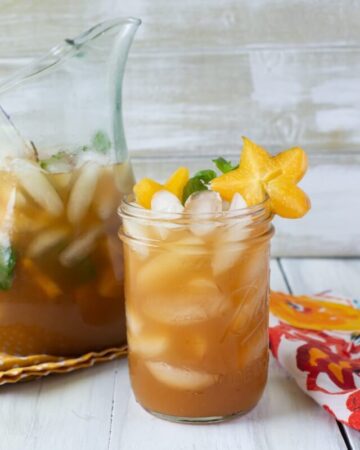 A glass and pitcher filled with Carambola Iced Tea.