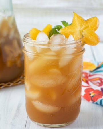 A close up photo of a glass full of freshly made Carambola Iced Tea Cooler