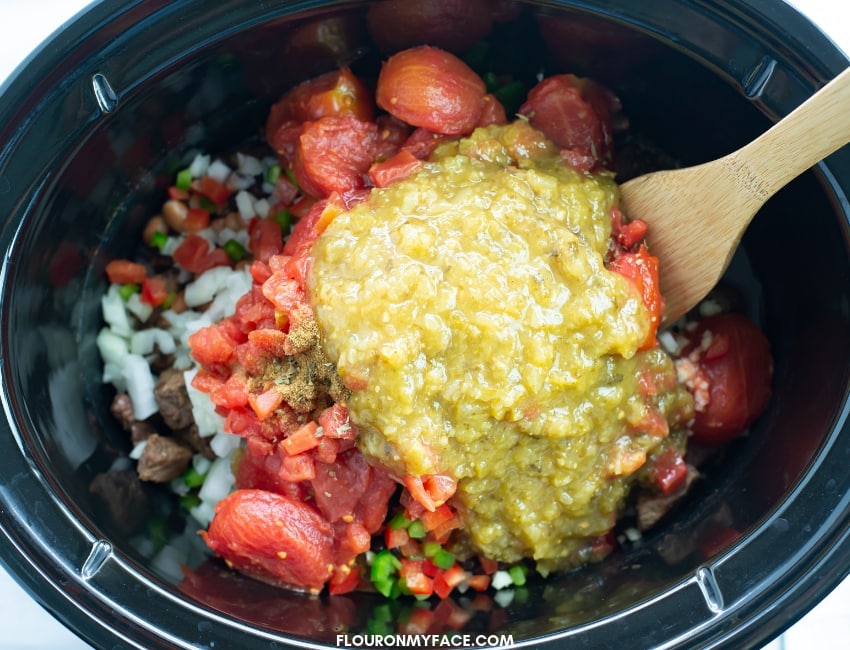 Filling a crock pot with the fresh and simple ingredients to make salsa Verde beef stew