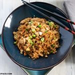 Cauliflower Chicken Fried Rice in a bowk with chops sticks