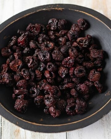 Dehydrated Cherries in a black wooden bowl.