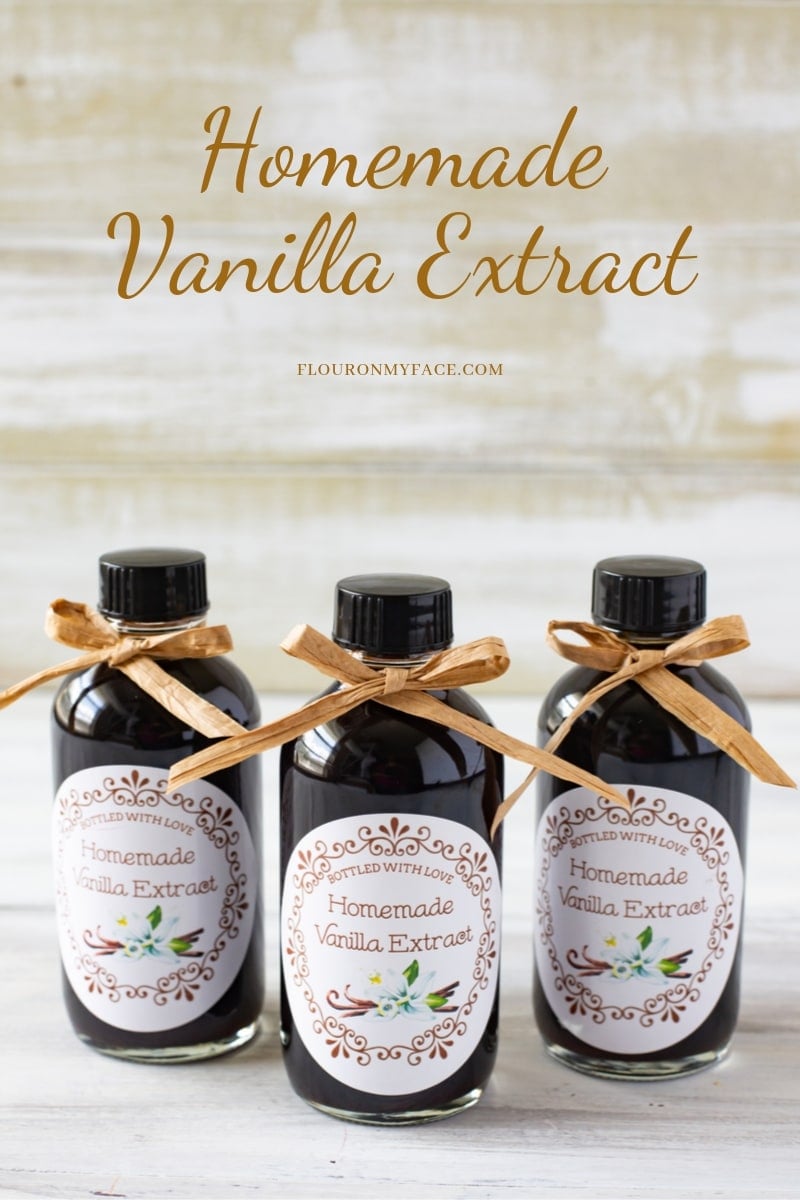 Close up featured image of 3 4 oz glass bottles filled with homemade vanilla extract, with a free custom made round vanilla extract label you can print from home. Bottles each have a brown rafia bow tie at the top of the bottle.