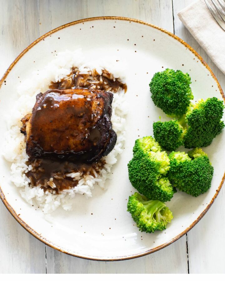 Balsamic chicken thigh served over rice with broccoli on the side.