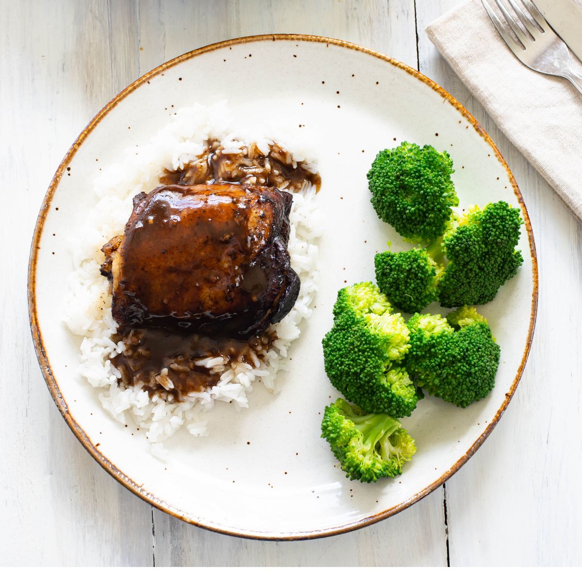 Balsamic chicken thigh served over rice with broccoli on the side.
