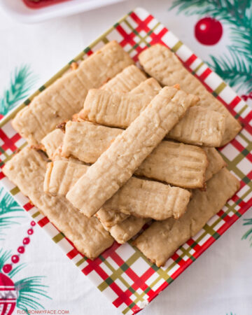 A Christmas plate with a pile of baked Coconut Washboard Cookies