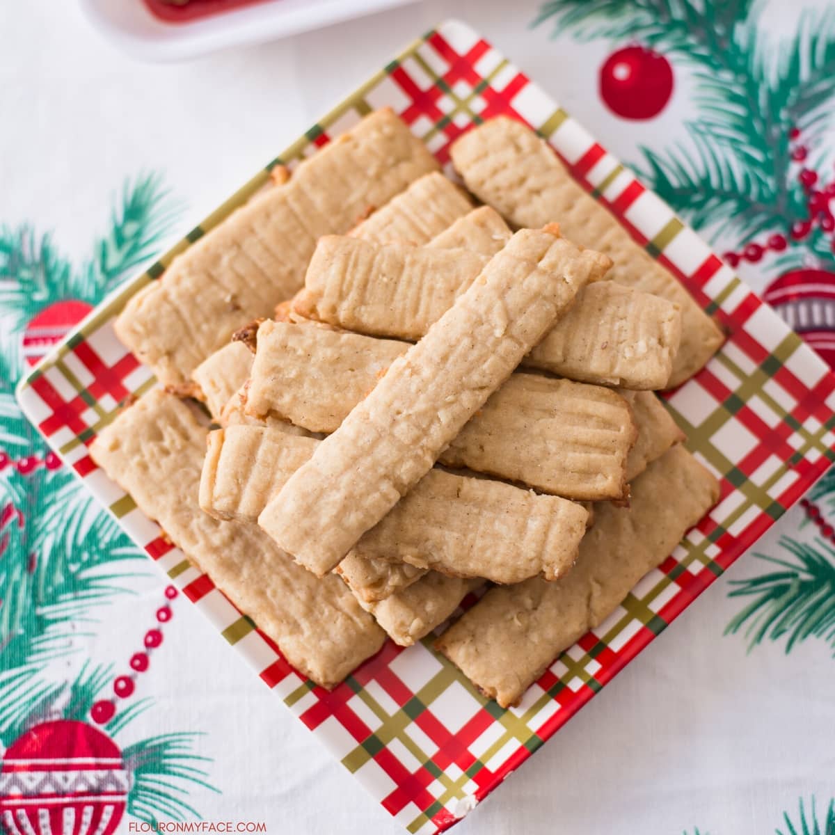 A Christmas plate with a pile of baked Coconut Washboard Cookies