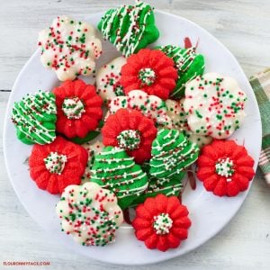 red, green and white Cream Cheese Spritz Cookies decorated with a powdered sugar glaze and Christmas sprinkles