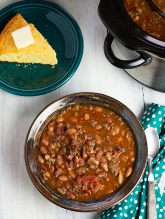 Crock Pot Cowboy Bean Soup in a bowl with a piece of cornbread in the background.