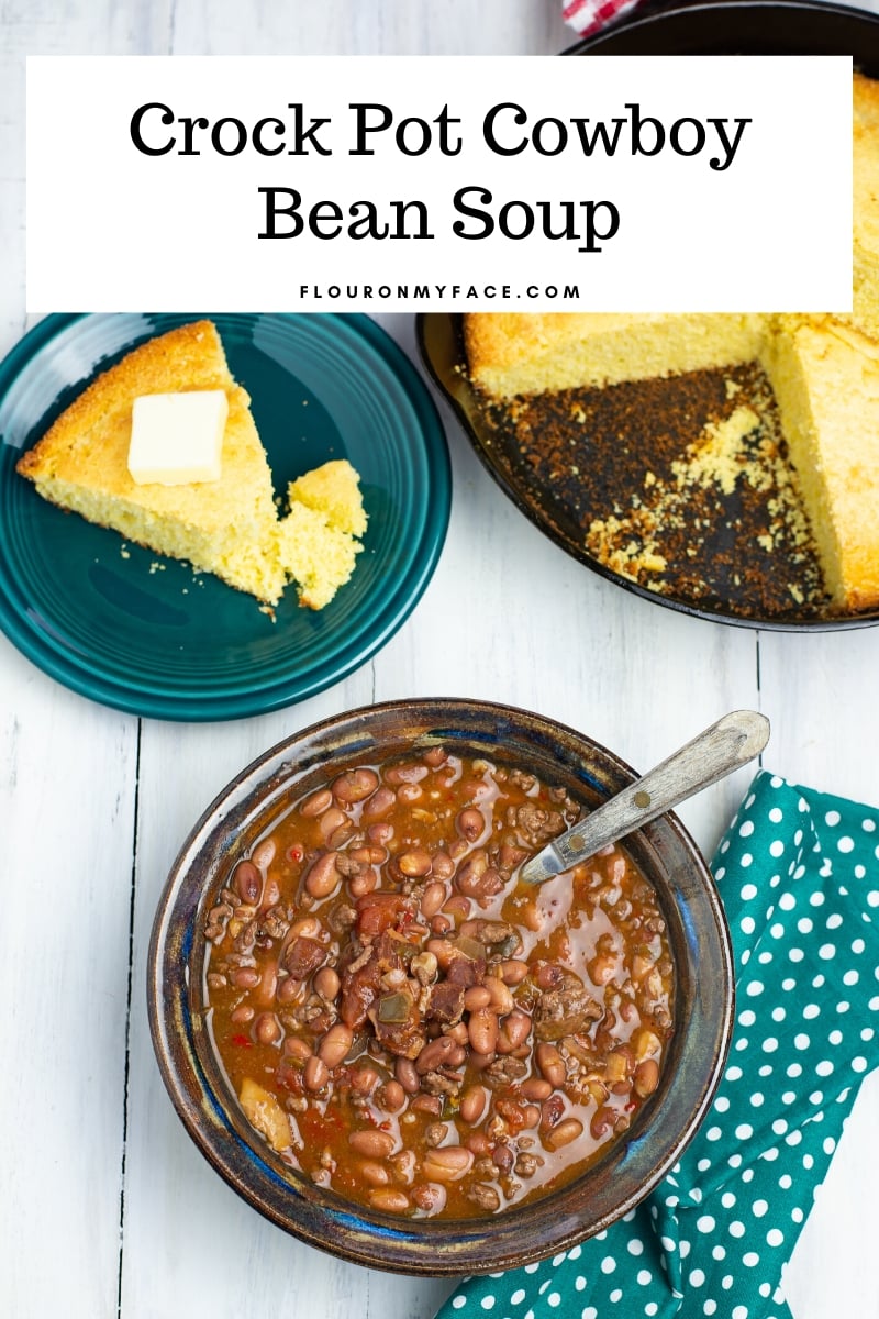 Overhead photo of one serving bowl of Cowboy Bean Soup with a iron skillet of freshly baked cornbread. The Crock Pot Cowboy Bean Soup recipe made with ground beef.