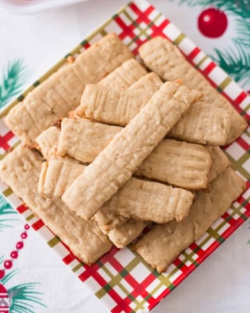 A Christmas plate with a pile of baked Coconut Washboard Cookies