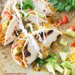 closeup photo of 3 IInstant Pot Creamy Chicken Tacos on a plate with taco toppings.