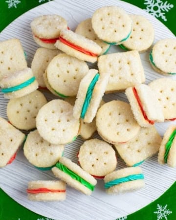 Christmas sandwich cookies on a holiday plate.