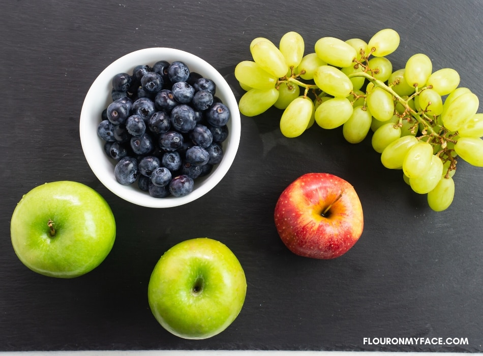 a photo of fresh granny smith and gala apples, green grapes and fresh blueberries