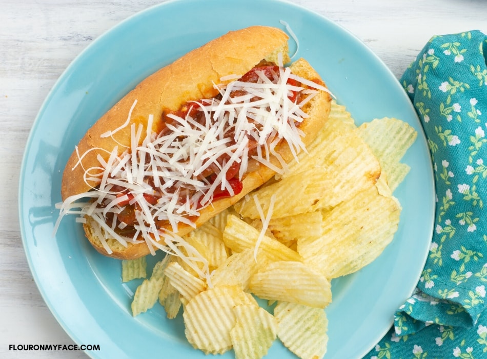 overhead photo of Instant Pot Sausage and Peppers Sandwiches served on a hoagie roll with shredded cheese
