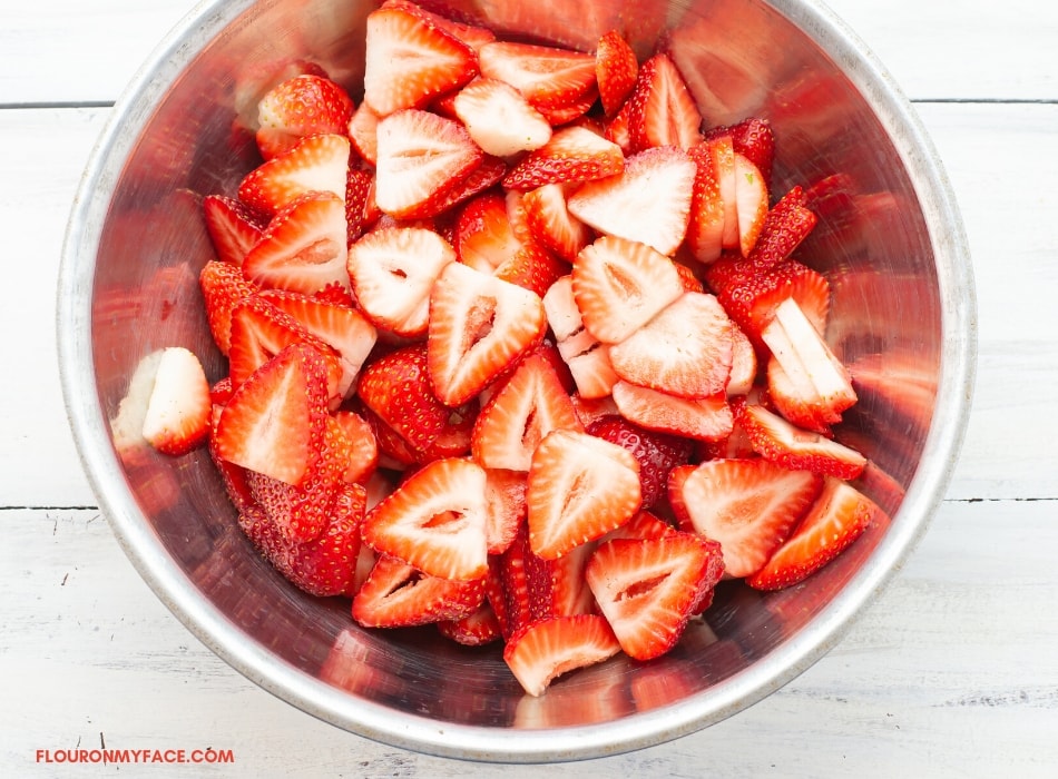 sliced strawberries in a metal bowl before loading into the food dehydrator