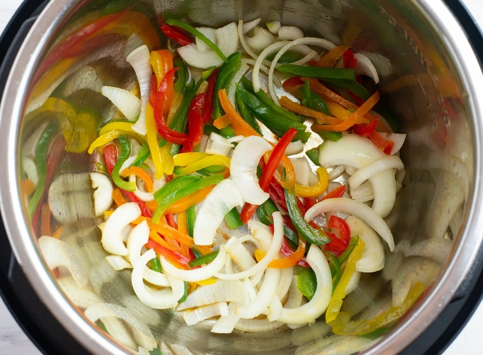 Step 2 adding the sliced peppers and onions to the Instant Pot insert