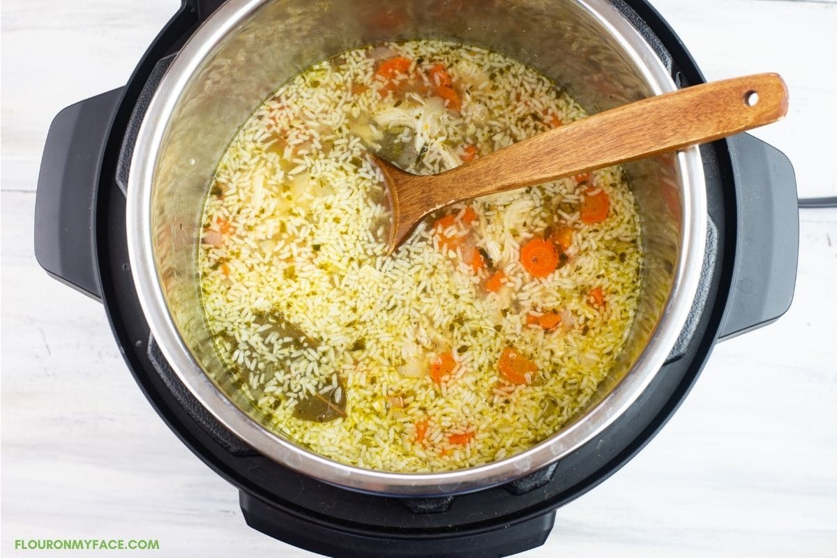 Adding instant rice to hot soup broth to cook.