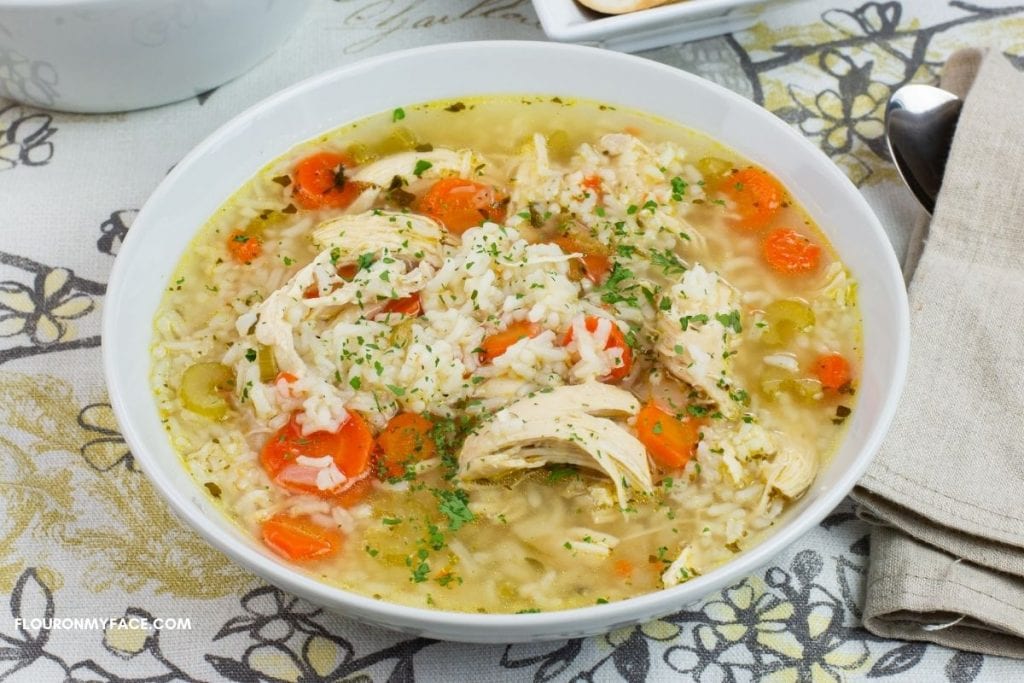 A white bowl filled with chicken and rice soup.