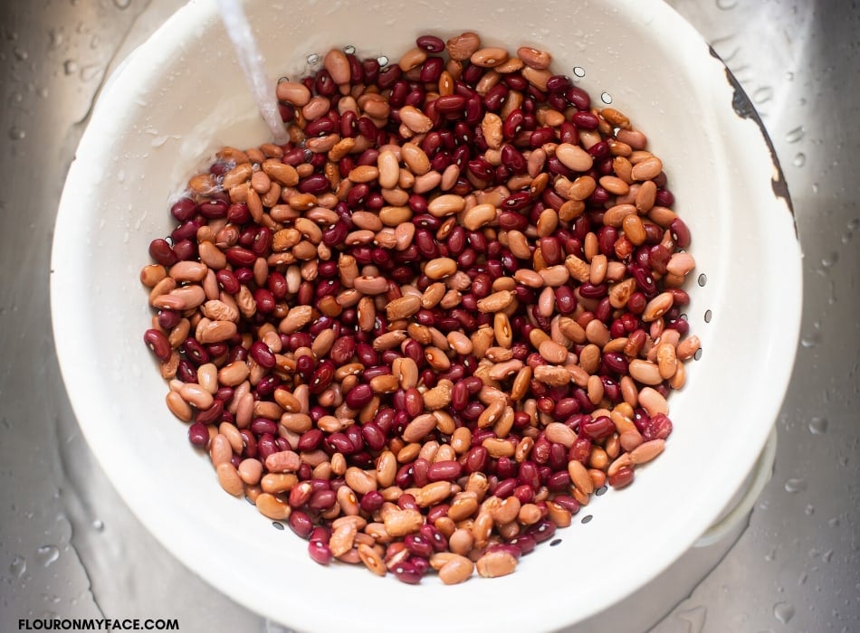Prepping dried beans by rinsing under cold water
