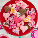 Valentines Day Spritz Cookies overhead photo with the Valentines day treats piled on a red cake stand