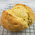 freshly baked round loaf of Irish Soda Bread on a metal cooling rack.