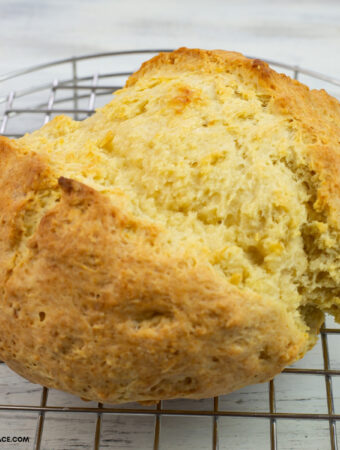 freshly baked round loaf of Irish Soda Bread on a metal cooling rack.