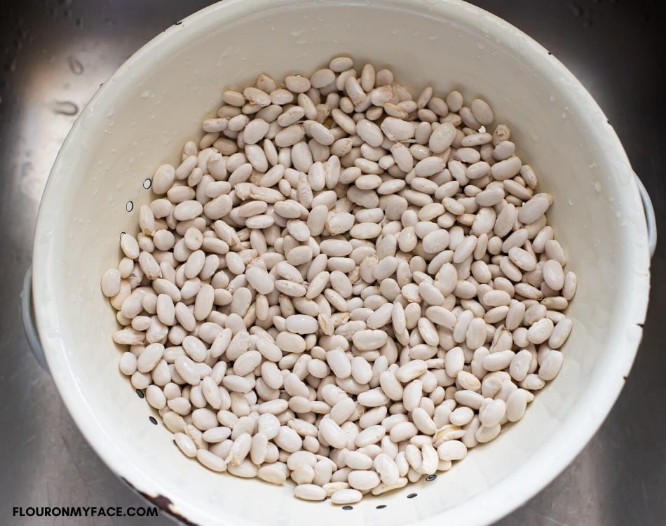 dried Great Northern Beans in a colander after rinsing with cold water