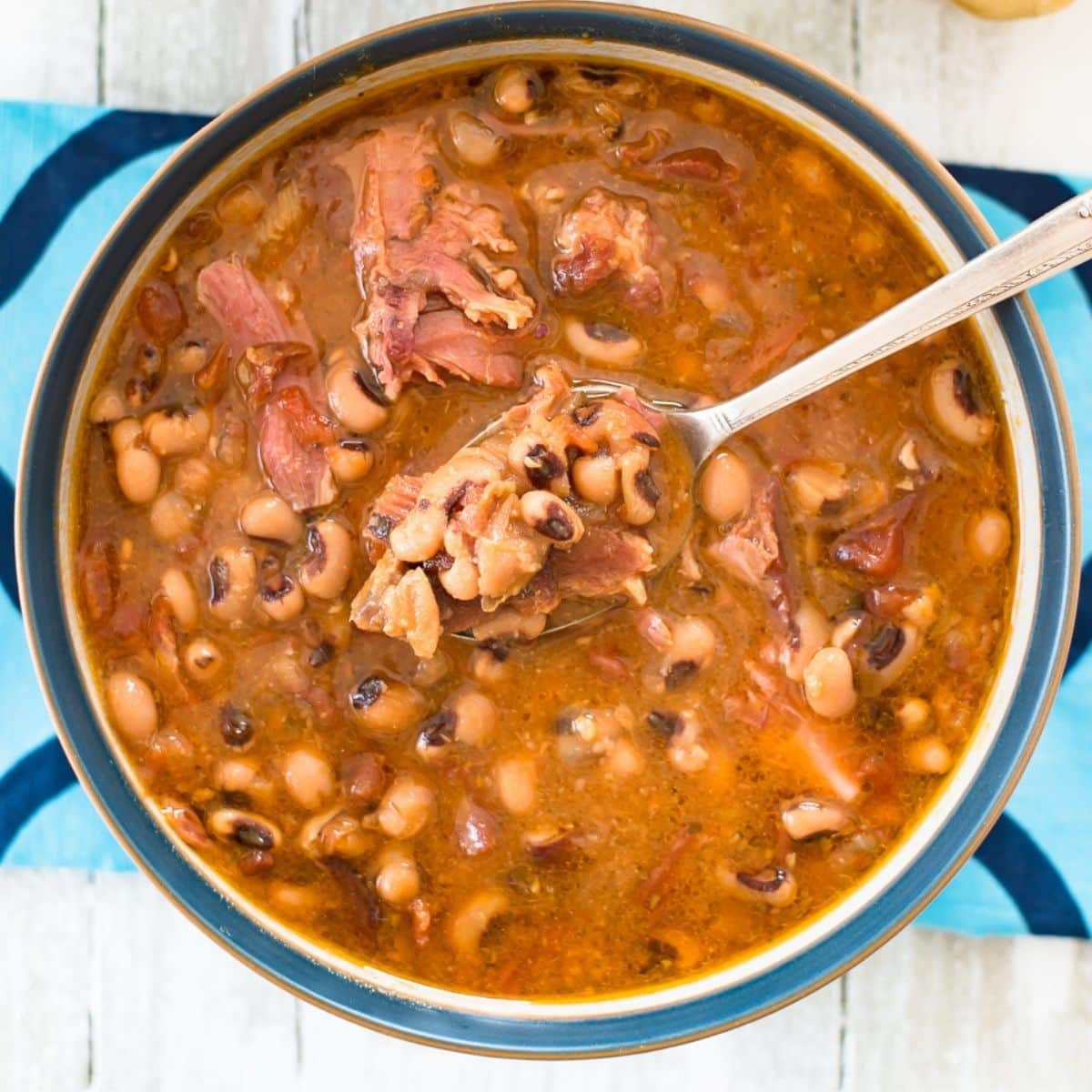 A soup bowl filled with slow cooked black eyed beans with ham.
