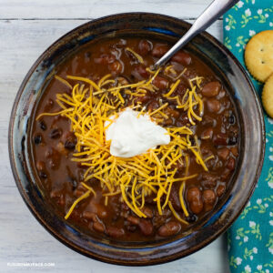 A bowl of Turkey Chili topped with shredded cheese and sour cream