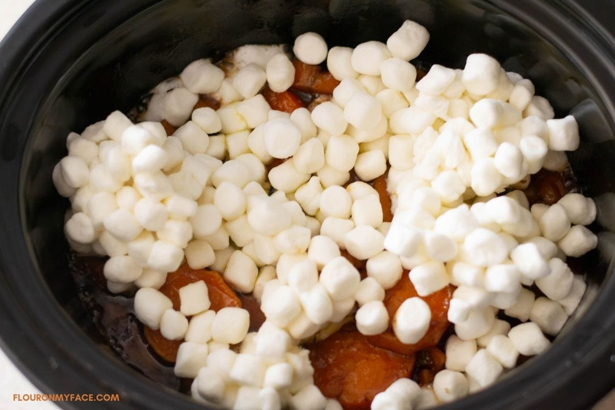 Mini marshmallows spread over sliced sweet potatoes.