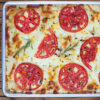 Overhead, closeup photo of a freshly baked Cheese Tomato Sourdough Focaccia