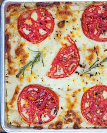 Overhead, closeup photo of a freshly baked Cheese Tomato Sourdough Focaccia