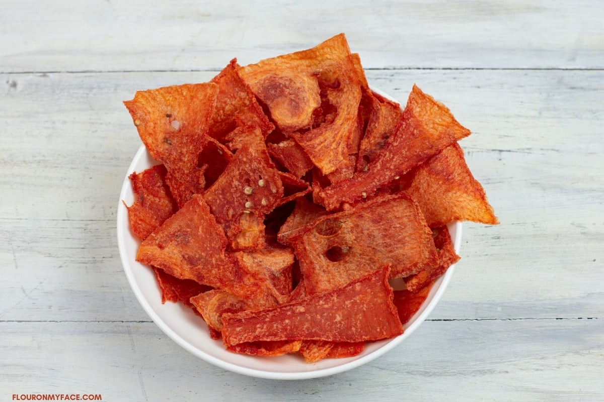 a white glass snack size bowl filled with pieces of dried watermelon