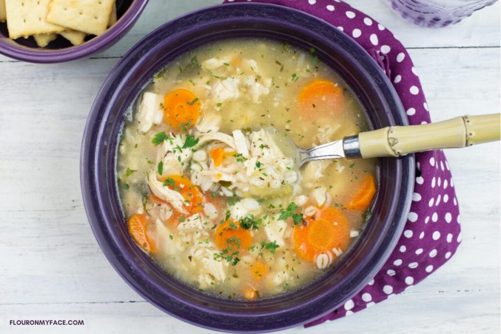 A bowl filled with homemade chicken and barley soup