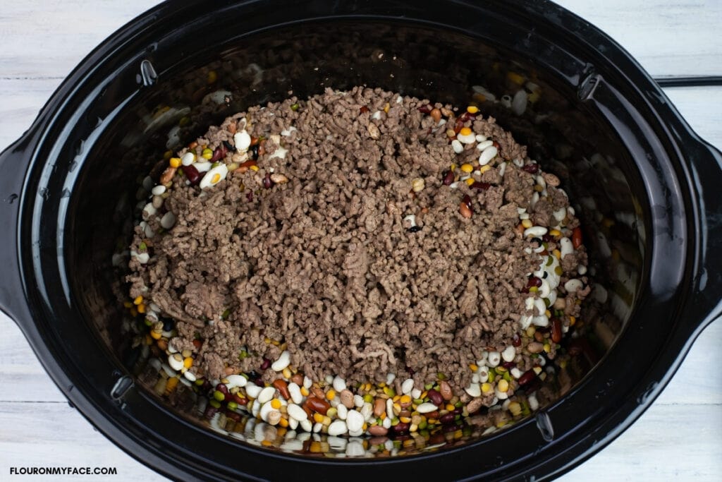 browned ground beef inside a slow cooker
