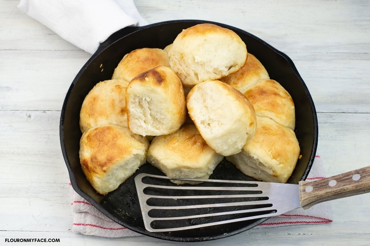sourdough pinch biscuits in a cast iron skillet after baking golden brown