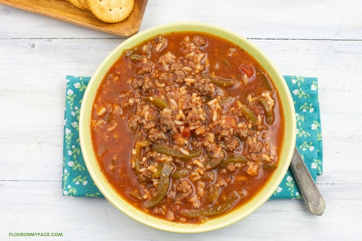 Stuffed Pepper Soup in a green bowl with a cloth napkin and crackers