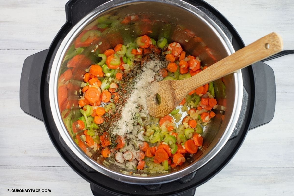 Adding herbs and spices to the sautéed vegetables 