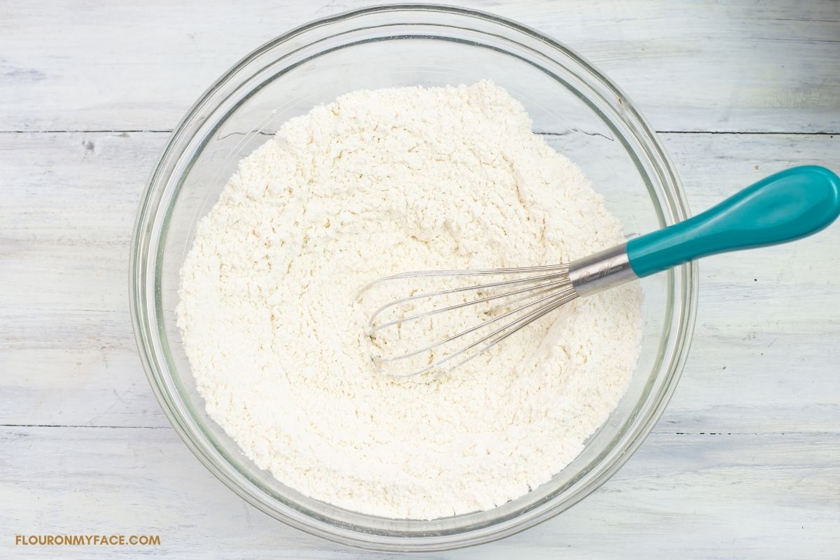 flour, baking soda and salt with a whisk in a mixing bowl.