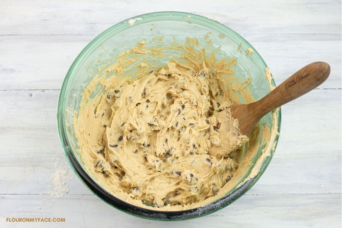 Folding chocolate chips into thick cookie dough.