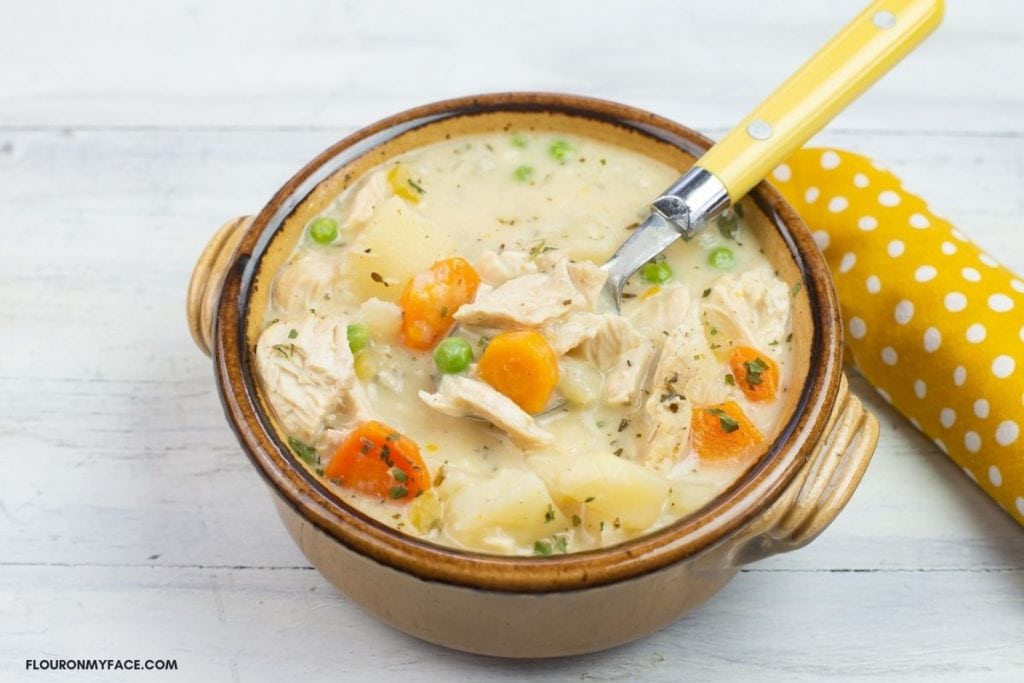 A brown soup bowl of thick creamy and hearty chicken stew