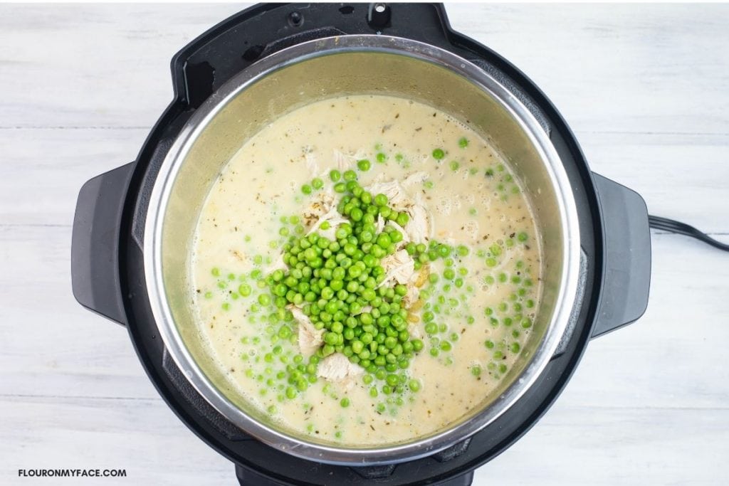 Adding the chicken and peas to chicken stew.