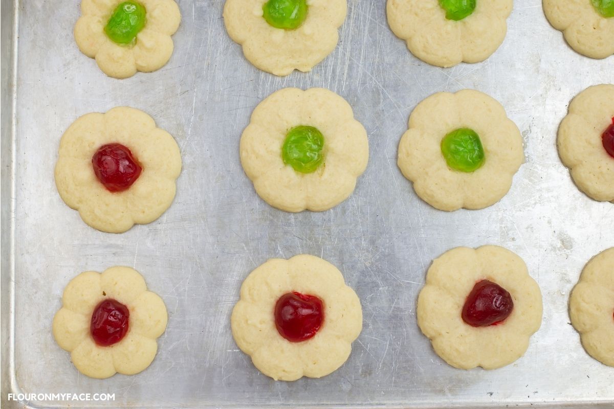 Baked Spritz cookies with cherry in center.