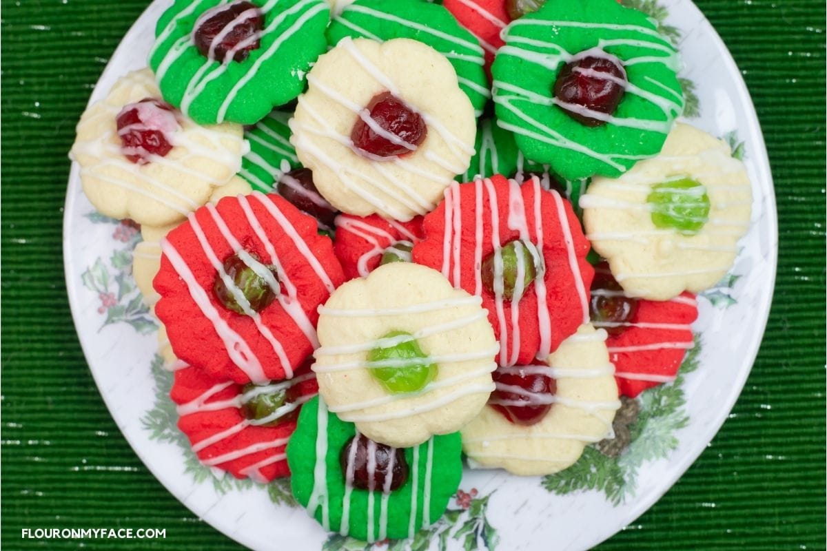 A plate with a pile of red, green and white Christmas cookies.