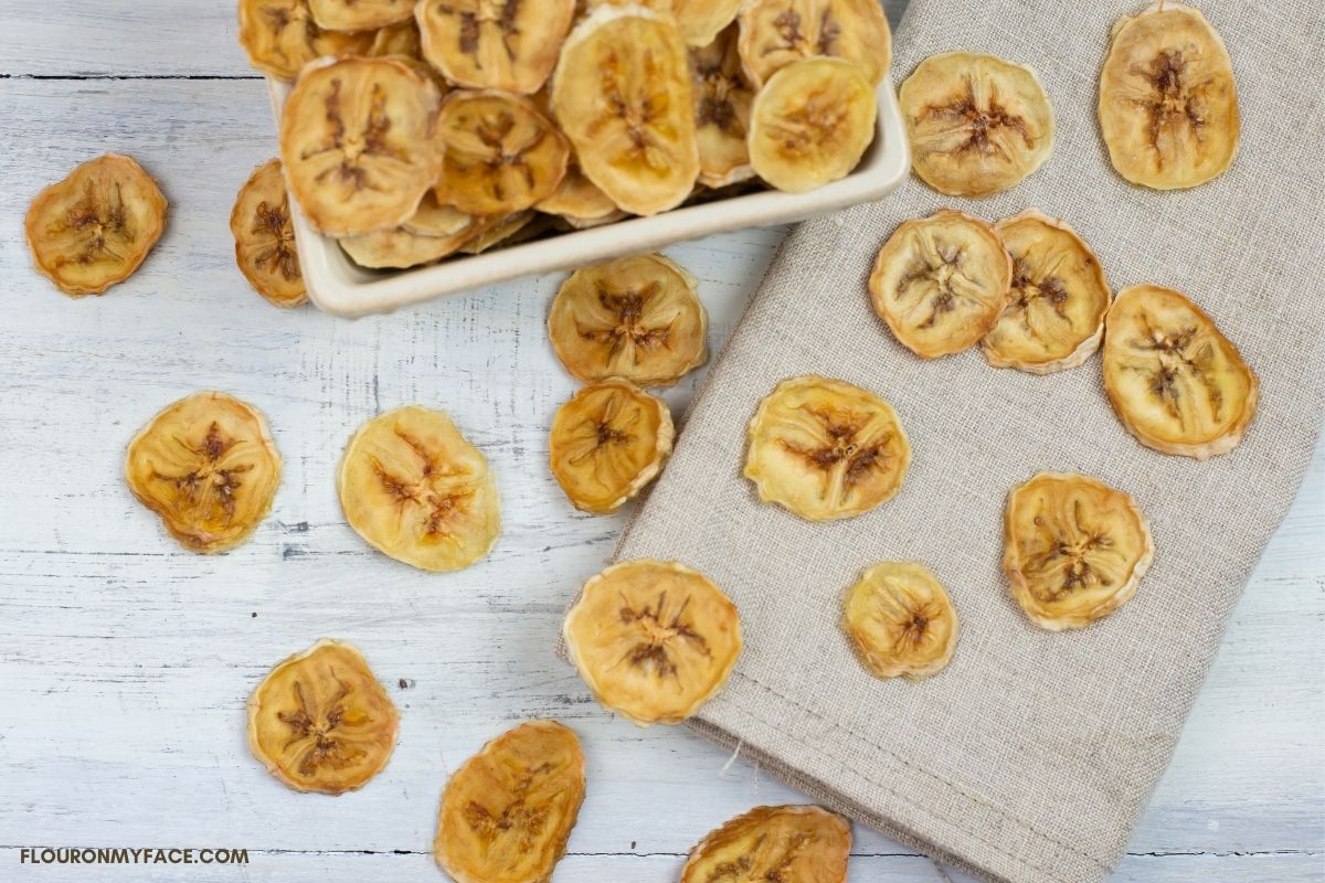 Dried banana chips scattered on a tan napkin.