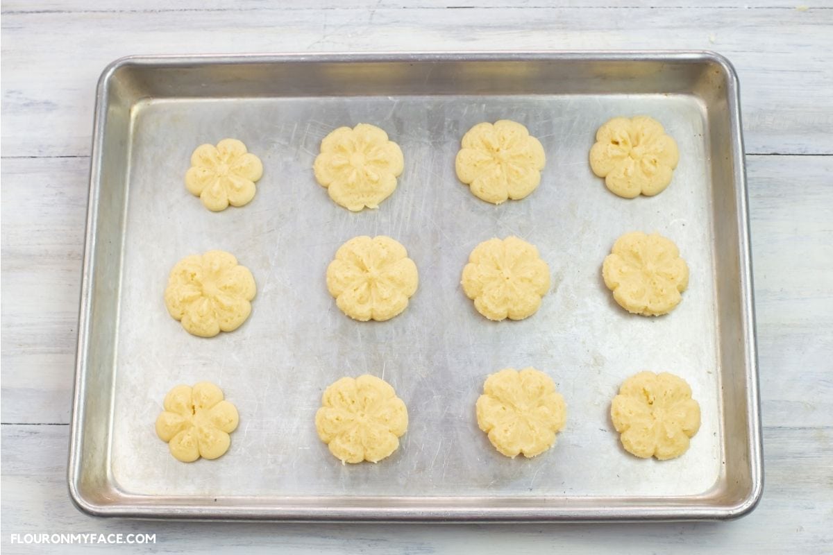 Cookie sheet filled with pressed cookies before baking.