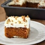 Closeup of a square piece of carrot cake with frosting.